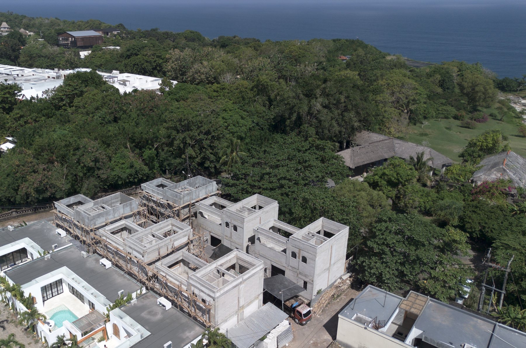 Aerial view of the six villas under construction, with the coast beyond